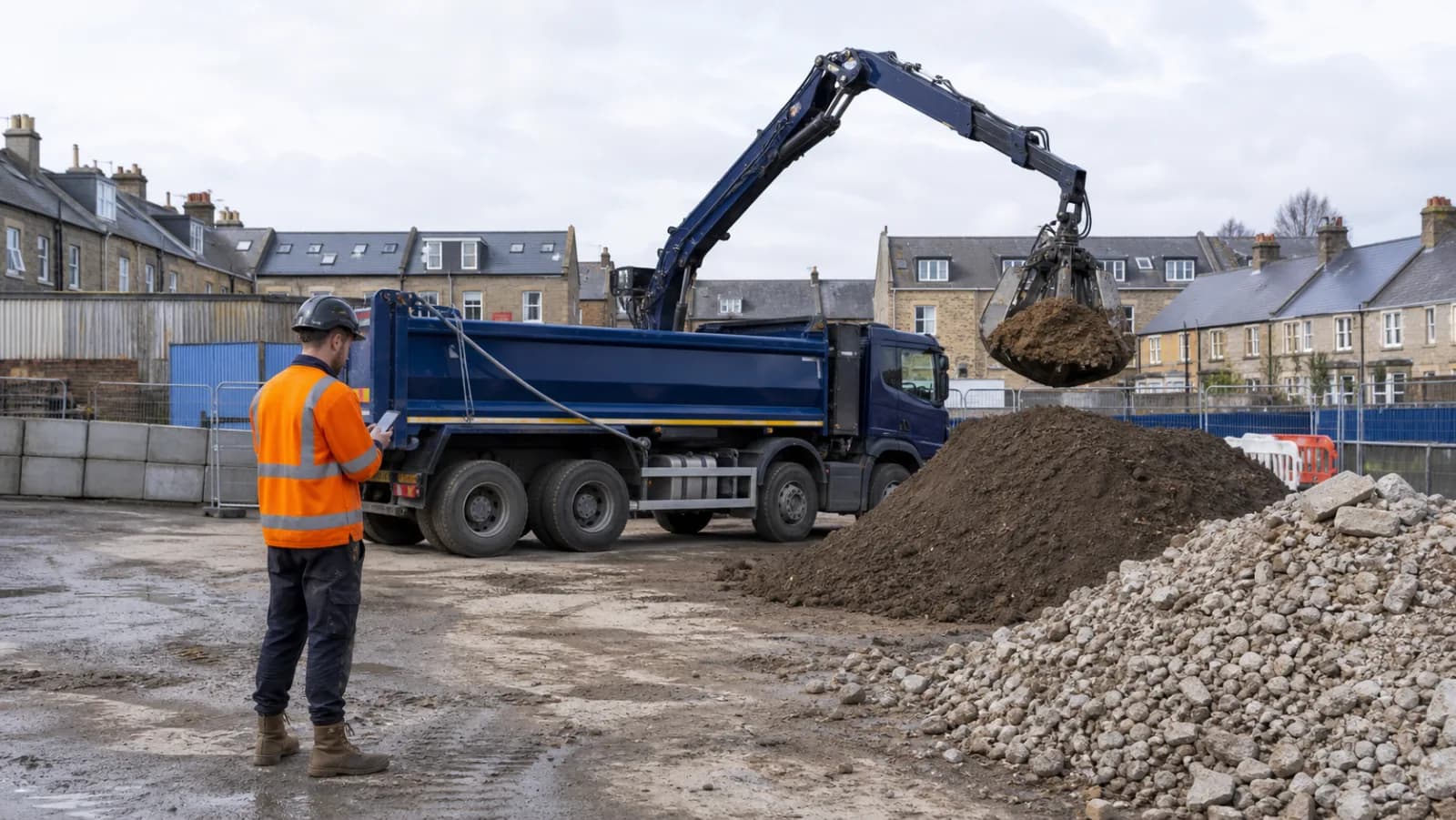 Grab lorry safely loading segregated soil and rubble on a small UK construction site